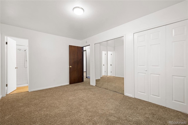 unfurnished bedroom featuring carpet, two closets, and ensuite bathroom