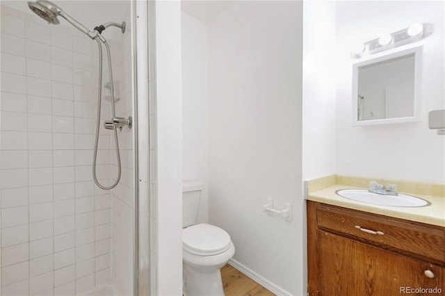 bathroom with vanity, toilet, wood-type flooring, and a shower with door