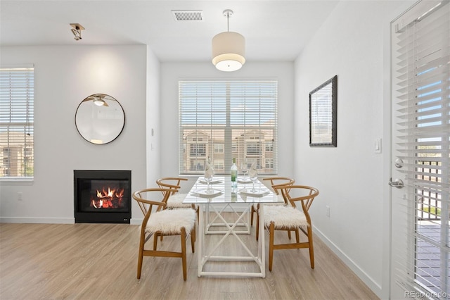 17353 Wilde Ave Unit 308, Parker, CO 80134 - dining area featuring wood finished floors, a glass covered fireplace, and plenty of natural light