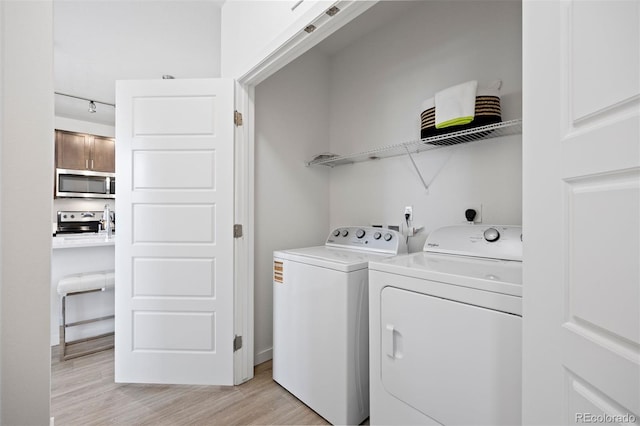 17353 Wilde Ave Unit 308, Parker, CO 80134 - washroom with washing machine and clothes dryer and light wood finished floors
