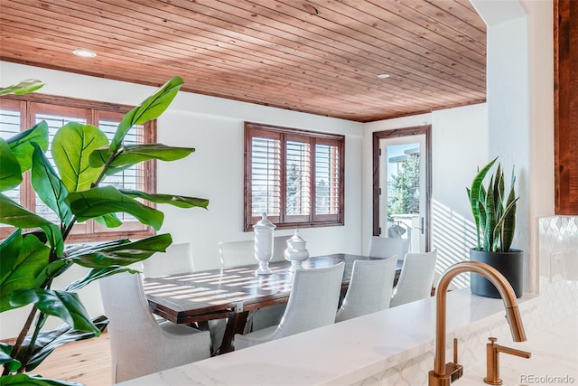 dining space featuring light hardwood / wood-style floors, wooden ceiling, and sink