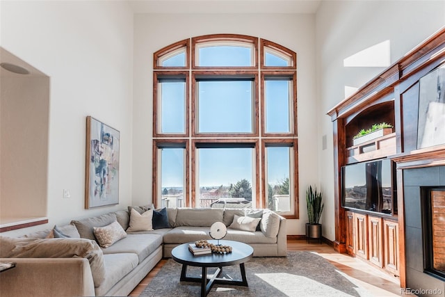 living room with a towering ceiling and light hardwood / wood-style floors