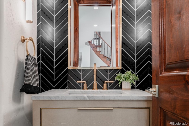 bathroom featuring vanity and decorative backsplash