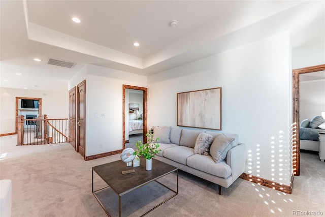 carpeted living room featuring a tray ceiling