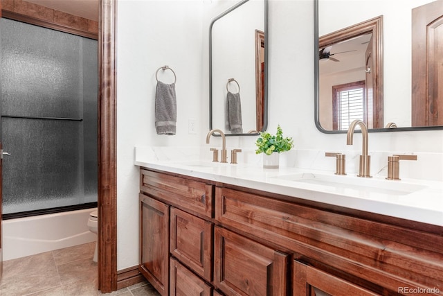 full bathroom featuring vanity, combined bath / shower with glass door, tile patterned flooring, ceiling fan, and toilet