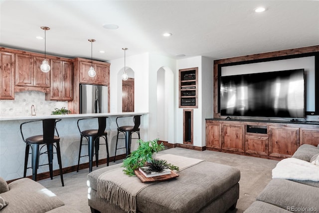 carpeted living room featuring built in shelves and sink