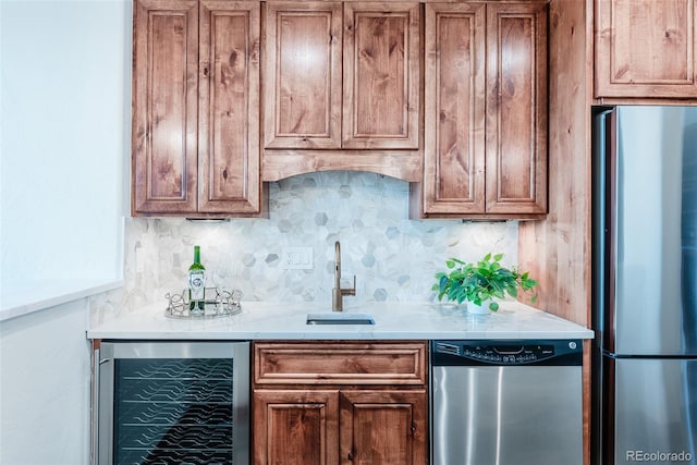 kitchen featuring stainless steel appliances, tasteful backsplash, sink, and beverage cooler