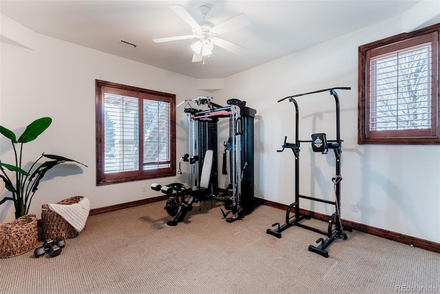 workout area featuring ceiling fan, a healthy amount of sunlight, and light colored carpet