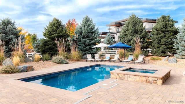 view of swimming pool with an in ground hot tub and a patio