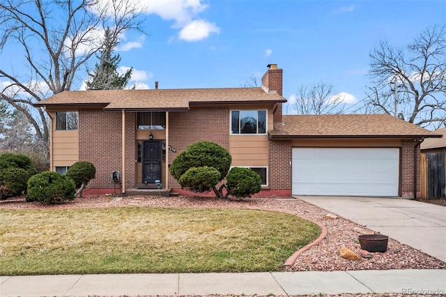 bi-level home featuring a front yard, an attached garage, brick siding, and concrete driveway