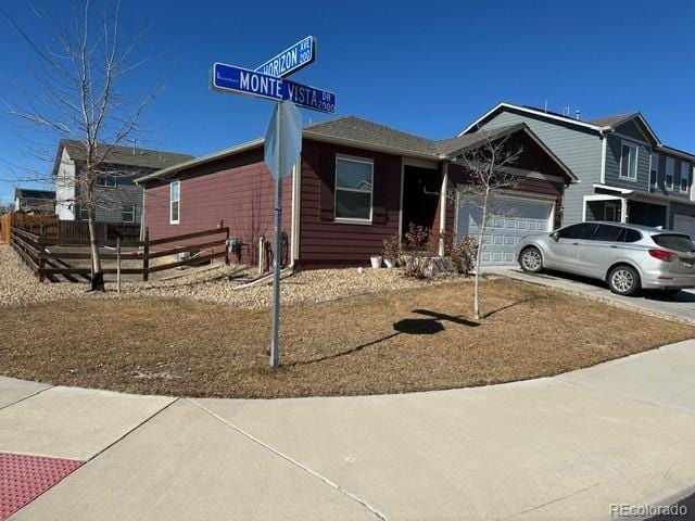 ranch-style house with a garage, driveway, and fence