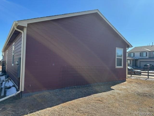 view of side of home featuring fence