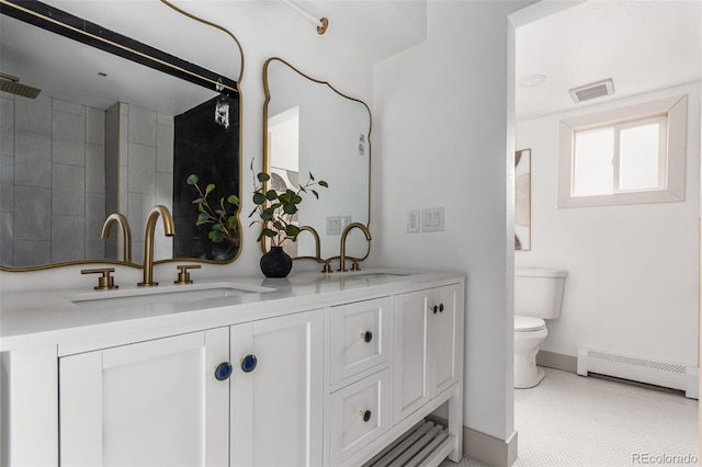 bathroom featuring toilet, vanity, and baseboard heating