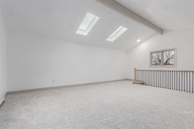 carpeted spare room featuring vaulted ceiling with beams