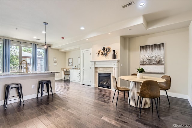2700 E Louisiana Ave Unit 203, Denver, CO 80210 - dining area with recessed lighting, baseboards, dark wood-style floors, and a tiled fireplace