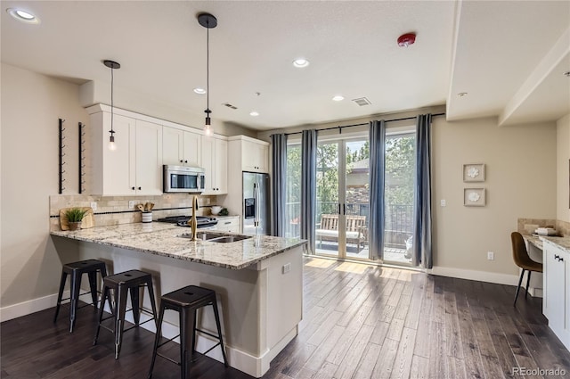 2700 E Louisiana Ave Unit 203, Denver, CO 80210 - kitchen featuring appliances with stainless steel finishes, baseboards, dark wood-style flooring, a peninsula, and recessed lighting