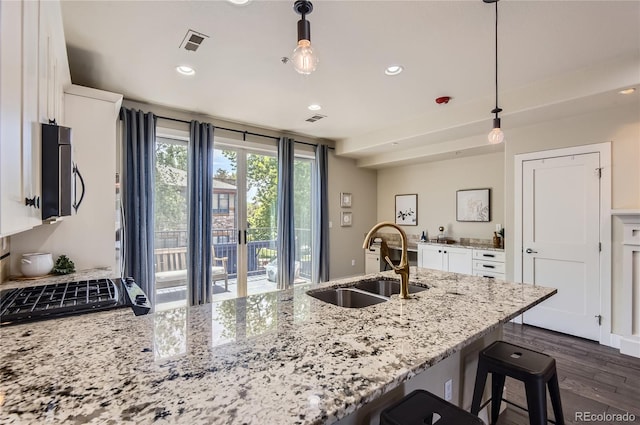 2700 E Louisiana Ave Unit 203, Denver, CO 80210 - kitchen with a sink, recessed lighting, white cabinetry, a peninsula, and light stone countertops