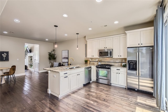 2700 E Louisiana Ave Unit 203, Denver, CO 80210 - kitchen with stainless steel appliances, a sink, a peninsula, white cabinetry, and recessed lighting
