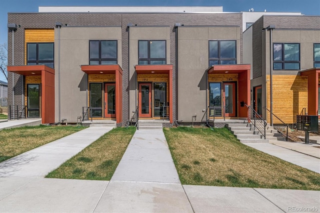 view of front of house featuring central air condition unit and a front lawn