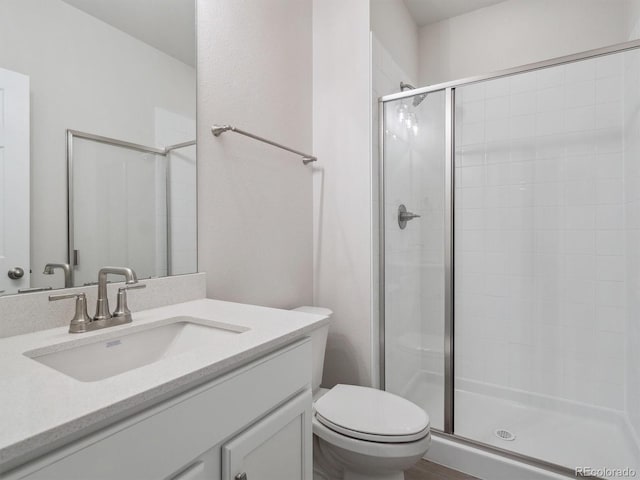 bathroom with toilet, an enclosed shower, and vanity