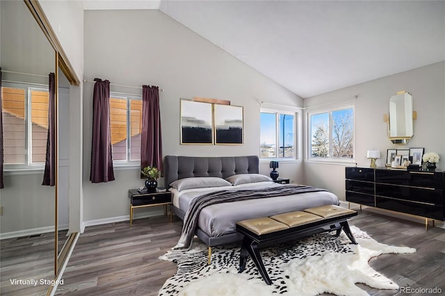 bedroom featuring hardwood / wood-style flooring, vaulted ceiling, and a closet