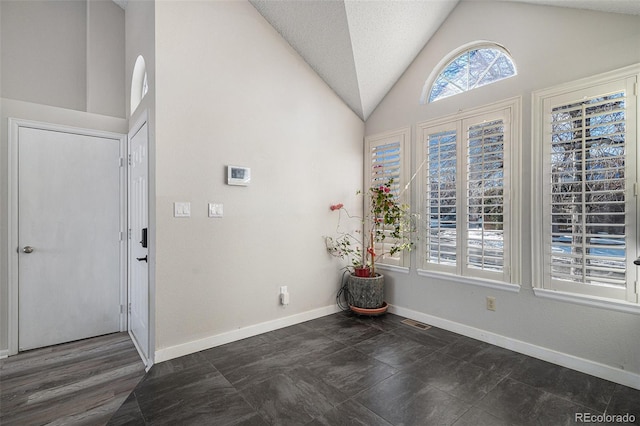 foyer featuring lofted ceiling and a textured ceiling