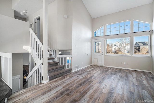 foyer with wood-type flooring and high vaulted ceiling