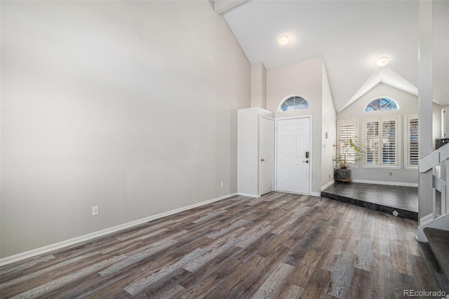 entrance foyer with dark wood-type flooring and high vaulted ceiling