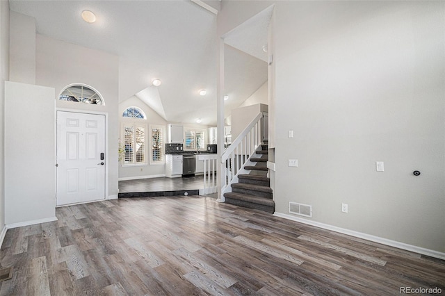 entryway with hardwood / wood-style floors and high vaulted ceiling