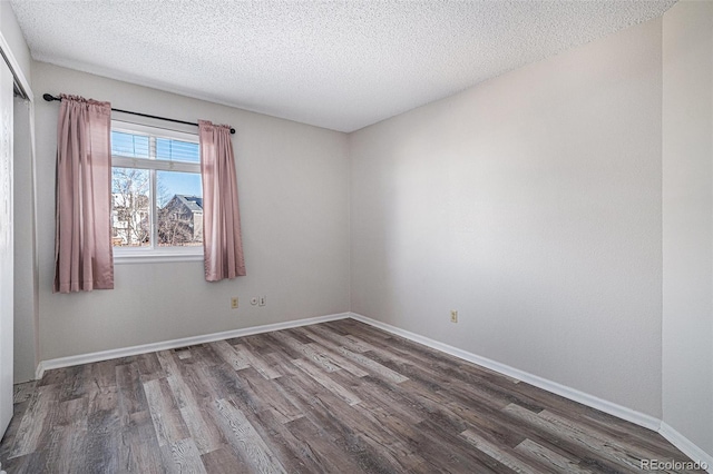 unfurnished room featuring hardwood / wood-style floors and a textured ceiling