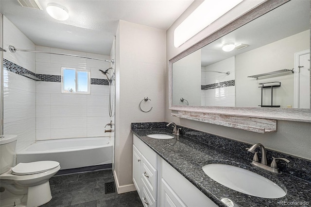 full bathroom with vanity, tiled shower / bath, and toilet