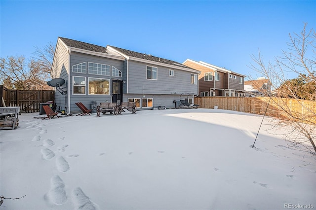 view of snow covered rear of property