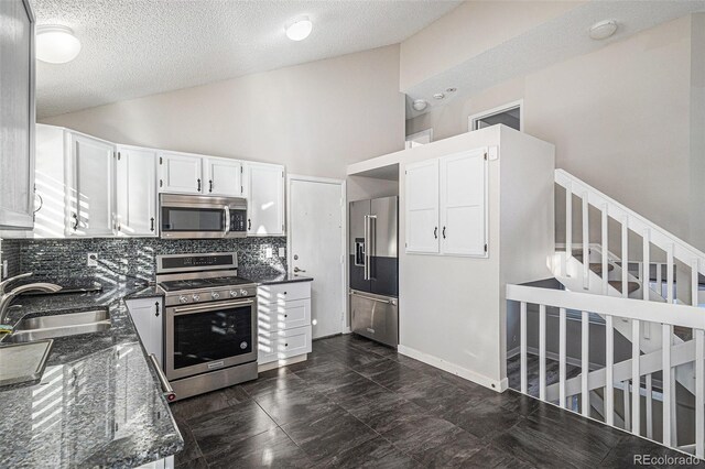 3738 Rosewalk Ct, Highlands Ranch, CO 80129 - kitchen with appliances with stainless steel finishes, a sink, backsplash, dark stone counters, and a textured ceiling