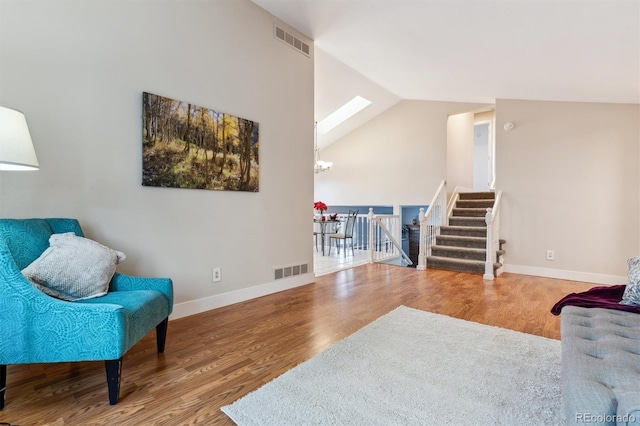 living area featuring hardwood / wood-style flooring and lofted ceiling with skylight