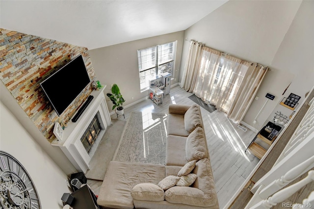 living room with light hardwood / wood-style floors and high vaulted ceiling