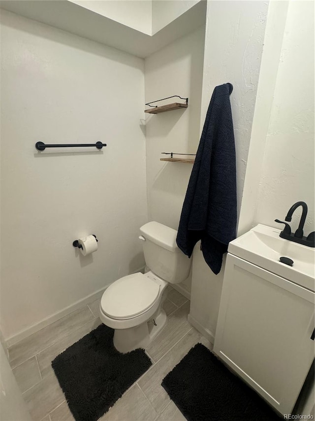 bathroom with hardwood / wood-style floors, vanity, and toilet