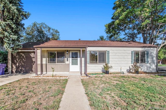 view of front of property with a garage, a front yard, roof with shingles, and driveway