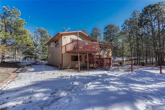 snow covered property with a deck