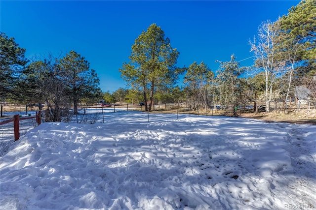 yard covered in snow with a rural view