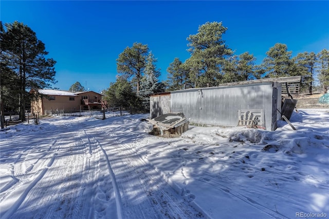 snowy yard featuring an outdoor structure