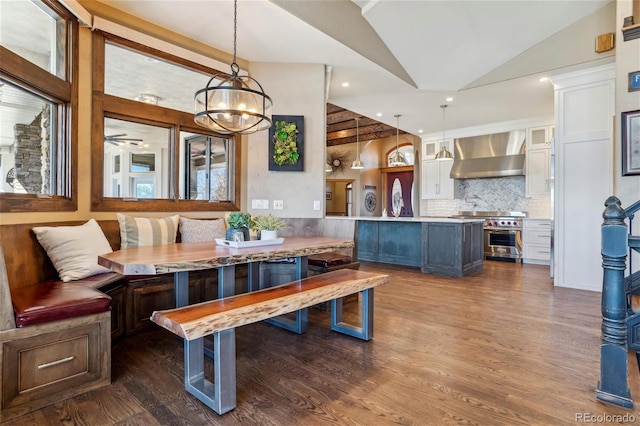 dining room featuring vaulted ceiling, a wealth of natural light, a chandelier, and dark hardwood / wood-style floors