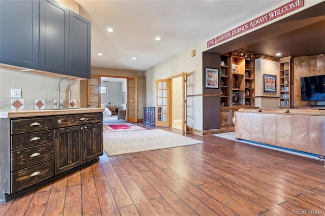 kitchen featuring built in shelves, french doors, sink, and hardwood / wood-style floors