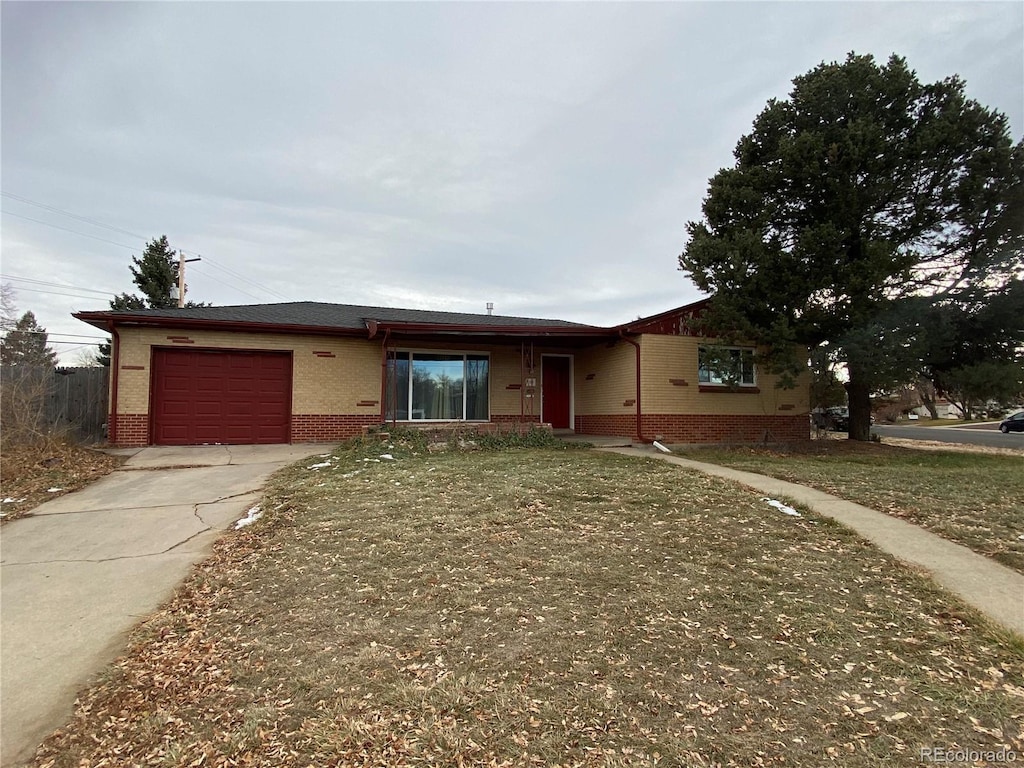 ranch-style home featuring a garage and a front lawn