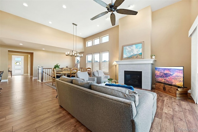 living area with light wood-type flooring, a high ceiling, baseboards, and recessed lighting