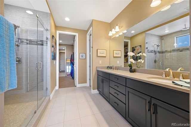 bathroom with a shower stall, a spacious closet, and a sink