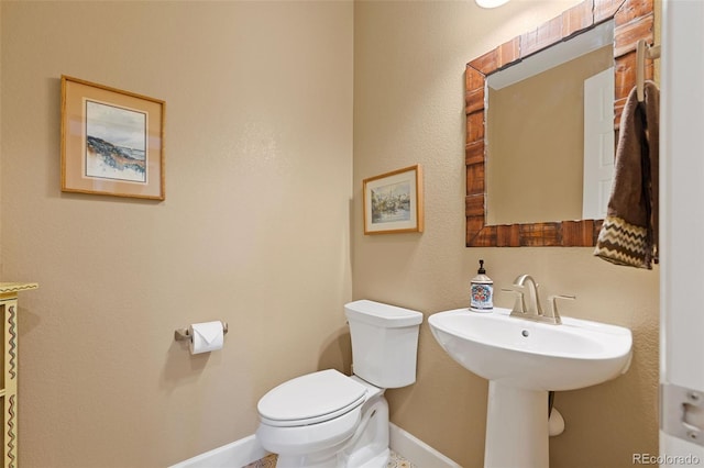 bathroom with toilet and baseboards