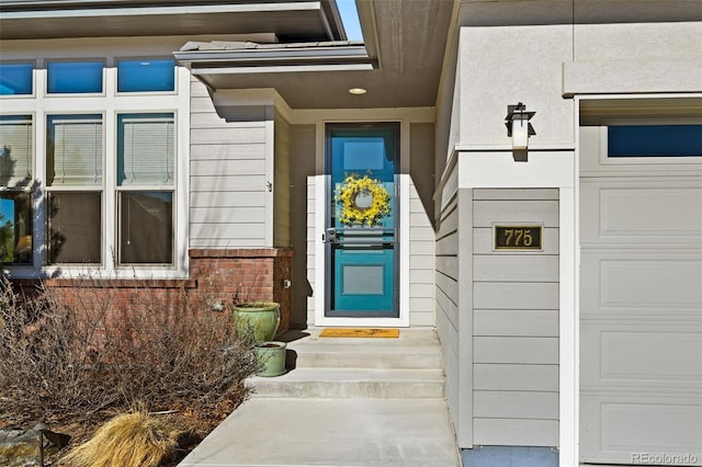 doorway to property with brick siding and a garage
