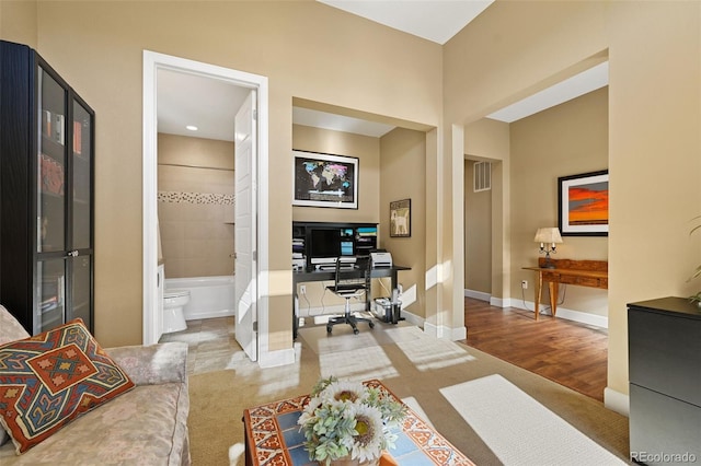 carpeted office space with baseboards and visible vents