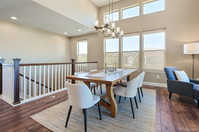 dining area with plenty of natural light, hardwood / wood-style floors, and a chandelier