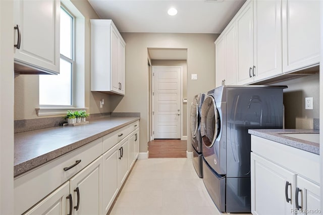 laundry room featuring baseboards, cabinet space, recessed lighting, and independent washer and dryer